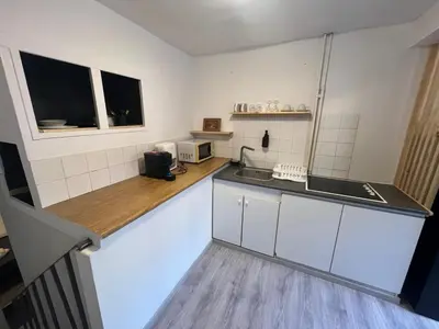 a kitchen with white cabinets and a counter top at European District Apartment Zero in Brussels