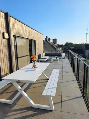 a white picnic table on the roof of a building at Penthouse with big terrace in Vilvoorde