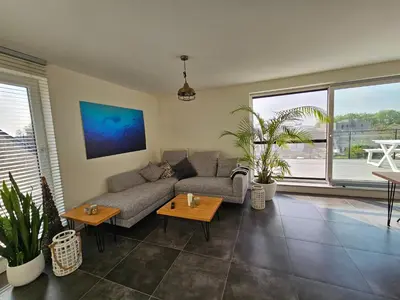 a living room with a couch and potted plants at Penthouse with big terrace in Vilvoorde