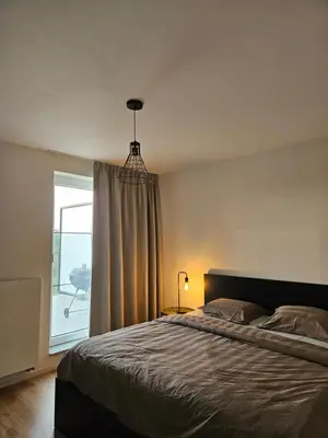 a bedroom with a bed and a window with a patio at Penthouse with big terrace in Vilvoorde