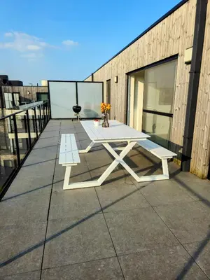 a white picnic table on the roof of a building at Penthouse with big terrace in Vilvoorde