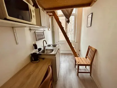 a small kitchen with a sink and a chair at European District Hostel in Brussels