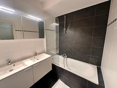 a bathroom with a tub and a sink and a mirror at Cosy 2 Bedroom Apartment in City Center in Brussels