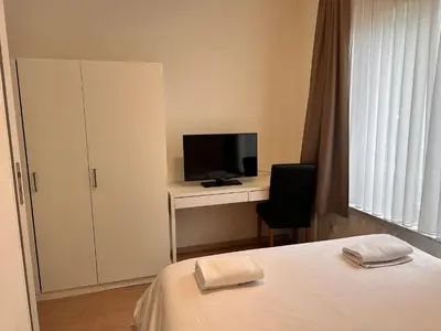a bedroom with a bed and a desk with a television at Cosy 2 Bedroom Apartment in City Center in Brussels