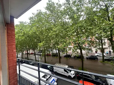 a balcony with a white truck parked on a street at Cosy 2 Bedroom Apartment in City Center in Brussels