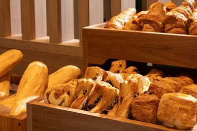 three wooden boxes filled with different types of bread at Holiday Inn Express Brussels - Airport by IHG in Diegem
