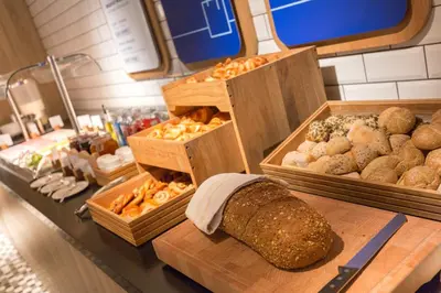 a bakery with bread and different types of pastries at Holiday Inn Express Brussels - Airport by IHG in Diegem