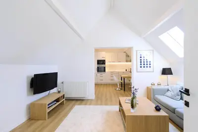 a living room with a couch and a tv at Le cottage de la Verte Voie in Wavre