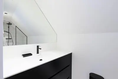 a white bathroom with a sink and a mirror at Le cottage de la Verte Voie in Wavre