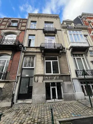 a large brick building with windows on a street at European District Apartment Seven in Brussels