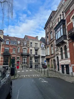 an empty street in a city with tall buildings at European District Apartment Seven in Brussels