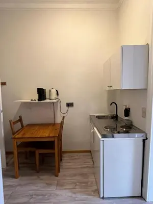 a small kitchen with a table and a sink at European District Apartment Eleven in Brussels