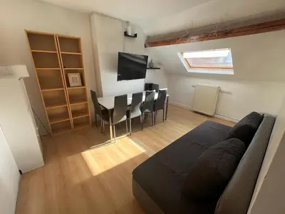 a living room with a couch and a table and chairs at European District Apartment Thirteen in Brussels
