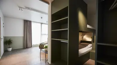 a room with a bedroom with a bed and a mirror at Vakantiewoning Het Kasterhuis in Wetteren
