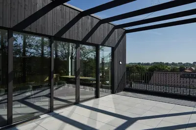 an open deck with glass doors and a patio at Vakantiewoning Het Kasterhuis in Wetteren