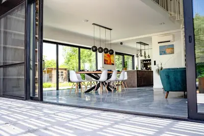a dining room and kitchen with a table and chairs at De Krekelberg in Brecht