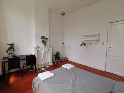 a white room with a bed and a desk in it at Cozy city centre room with parkview in Ghent