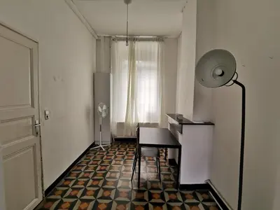 a room with a desk and a lamp and a window at Spacious room in city centre in Ghent