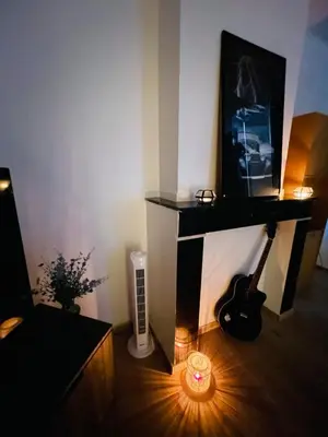a room with a television and a guitar and a candle at Heart of Antwerp in Antwerp