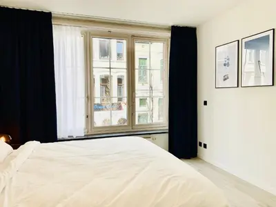 a bedroom with a white bed and a window at Belfort Shortstay in Ghent