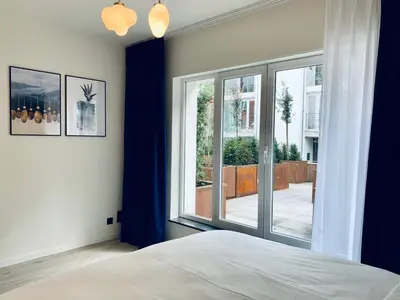 a bedroom with a bed and a large window at Belfort Shortstay in Ghent