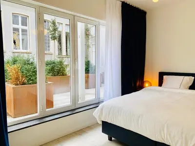 a bedroom with a bed and a large window at Belfort Shortstay in Ghent