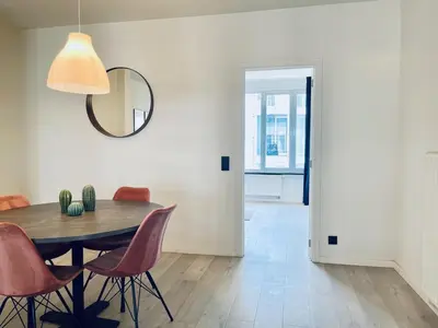 a dining room with a table and chairs and a mirror at Belfort Shortstay in Ghent