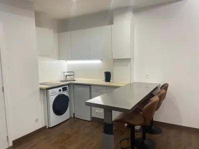 a kitchen with white cabinets and a table and chairs at Boutique Diamond Apartments in Antwerp