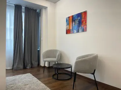 a room with two chairs and a table and a painting at Boutique Diamond Apartments in Antwerp