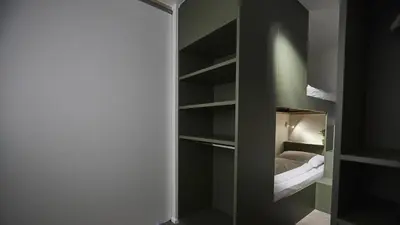 a bedroom with a closet with a bed in it at Het Kasterhuis in Wetteren