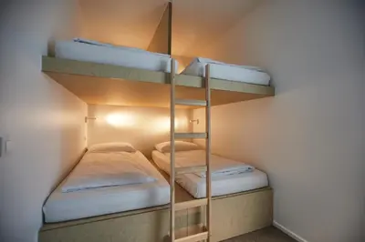 two bunk beds in a small room with a ladder at Het Kasterhuis in Wetteren