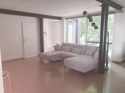 a living room with a white couch and a table at Portus Ganda in Ghent