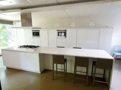 a kitchen with a large white island with stools at Portus Ganda in Ghent