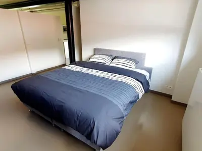 a bedroom with a bed with blue sheets and pillows at Portus Ganda in Ghent