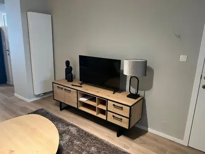 a living room with a flat screen tv on a cabinet at Appartement Martine in Brussels