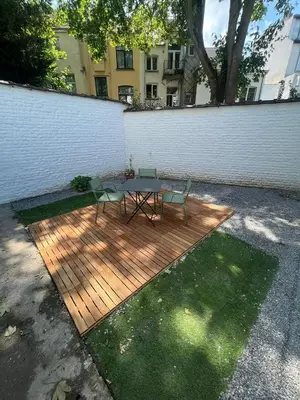 a picnic table and two chairs on a wooden deck at Appartement Martine in Brussels