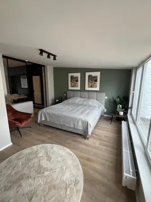 a bedroom with a bed and a large window at Appartement Martine in Brussels
