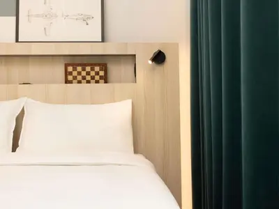 a bedroom with a bed and a green curtain at Aparthotel Adagio Access Brussels Airport in Machelen