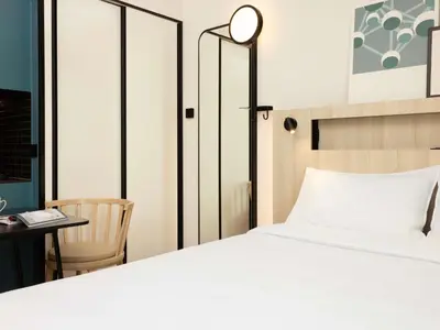 a bedroom with a bed and a table and a chair at Aparthotel Adagio Access Brussels Airport in Machelen
