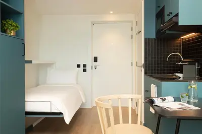 a small bedroom with a bed and a table at Aparthotel Adagio Access Brussels Airport in Machelen