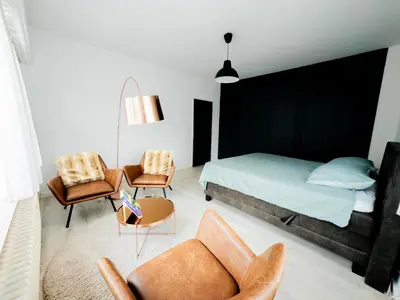 a bedroom with a bed and a couch and chairs at Capstay Sweet home in Willebroek