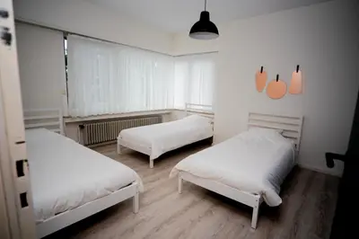 two beds in a room with white sheets at Capstay Sweet home in Willebroek
