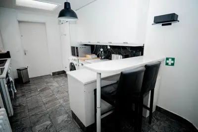 a kitchen with a white counter and two chairs at Capstay Sweet home in Willebroek