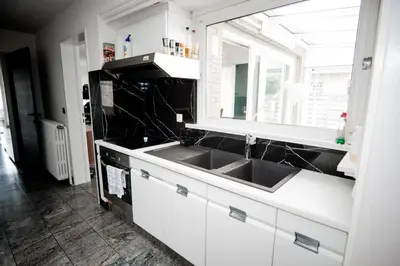 a white kitchen with a sink and a window at Capstay Sweet home in Willebroek