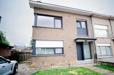 a brick house with a car parked in front of it at Capstay Sweet home in Willebroek