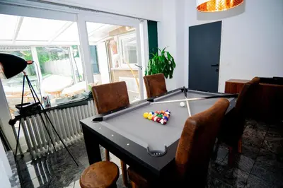a room with a pool table in a room with chairs at Capstay Sweet home in Willebroek