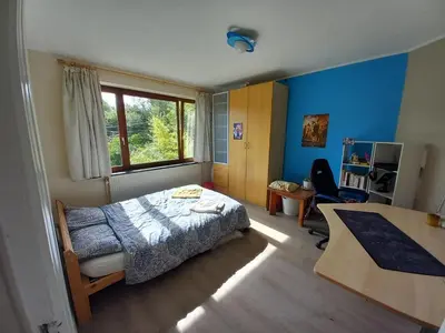 a bedroom with a bed and a desk and a window at Maison d'hôte in Grez-Doiceau