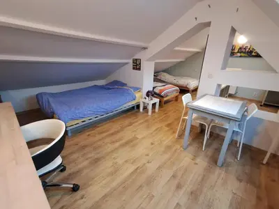 a bedroom with a bed and a table and chairs at Maison d'hôte in Grez-Doiceau