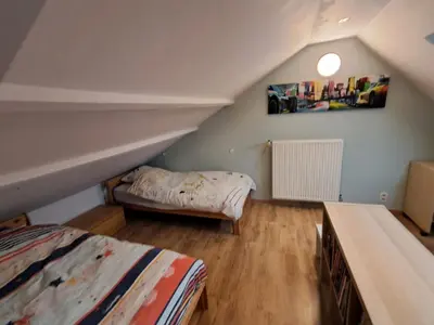 a attic room with two beds and a couch at Maison d'hôte in Grez-Doiceau