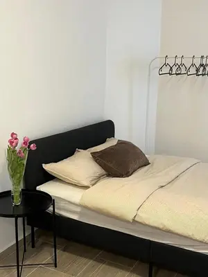 a bed with a black headboard and a vase of flowers at Studio n1 Bruxelles Centre Ville in Brussels